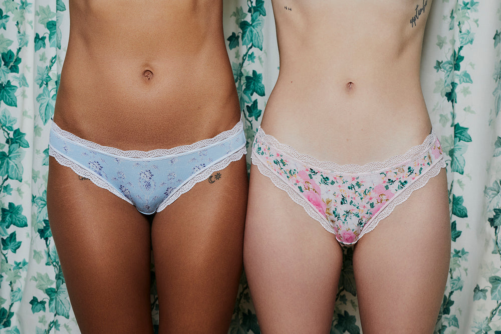 Two models stood in front of a shower curtain wearing floral knickers